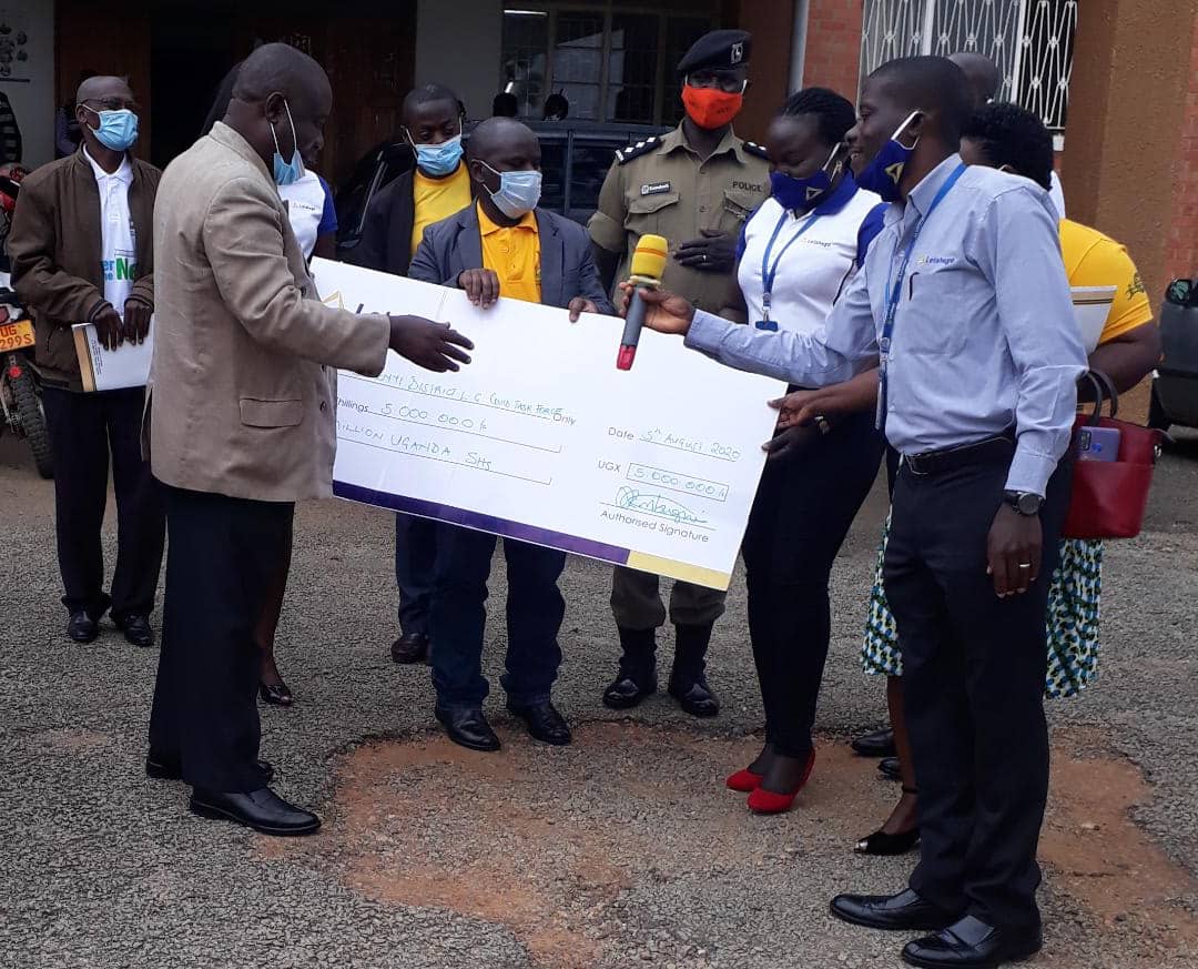 (L-R) CAO Bushenyi district Mahabba Malik receives microphone from Joseph Kimbugwe  (Head of MSE). This was during Letshego's donation towards Covid-19 support worth UGX5m