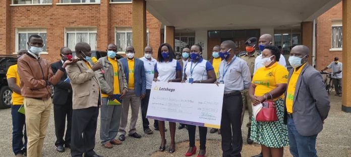 Bushenyi district CAO Mahabba Malik (with microphone) applauds the team from Letshego Uganda led by Joseph Kimbugwe (Head of MSE) during the UGX5M support to the Bushenyi Covid-19 Task Force handover in Bushenyi last weekend